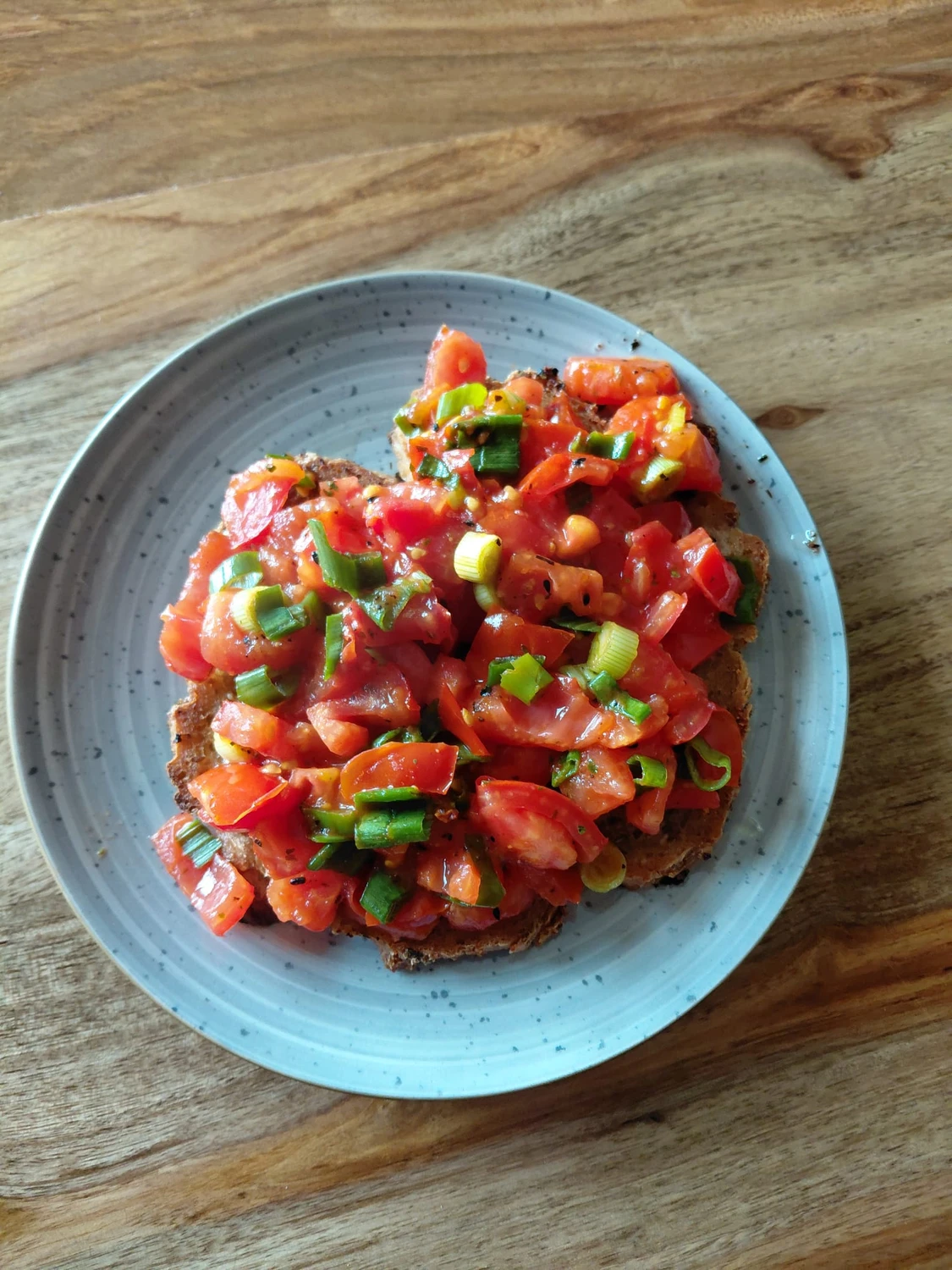 NaturTeller – vegane Ernährungsberatung - Eine helle, flache Schüssel mit einem cremigen Gemüsecurry, serviert mit Reis. Das Curry links enthält Blumenkohlröschen, in Scheiben geschnittene braune Champignons und Frühlingszwiebeln in einer gelblichen Soße. Rechts befindet sich ein Berg weißen Reis, ebenfalls mit gehackten Frühlingszwiebeln garniert.